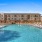 Large swimming pool with lounge chairs in shallow water
